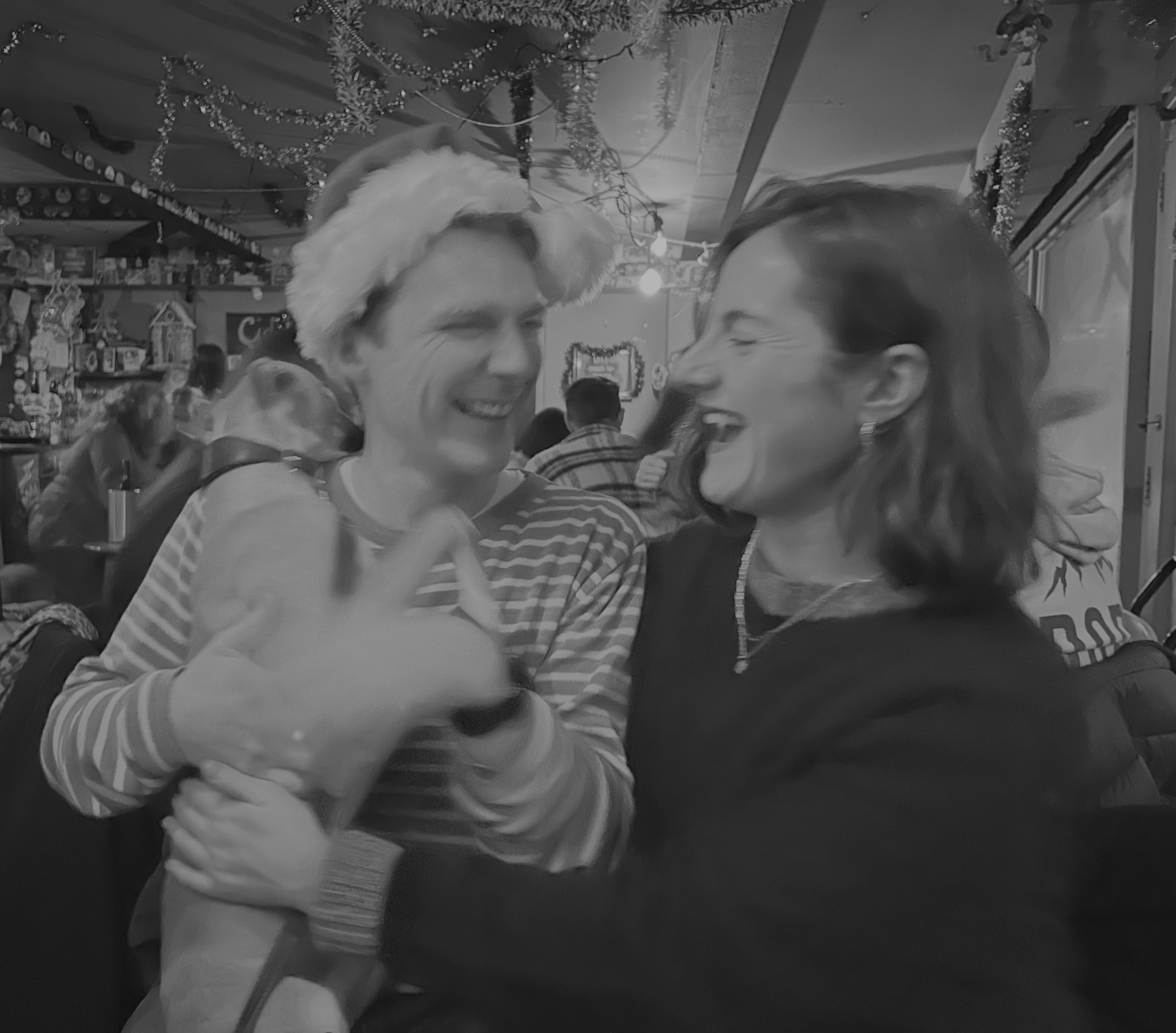 Bethany and Georges laughing together at a festive gathering